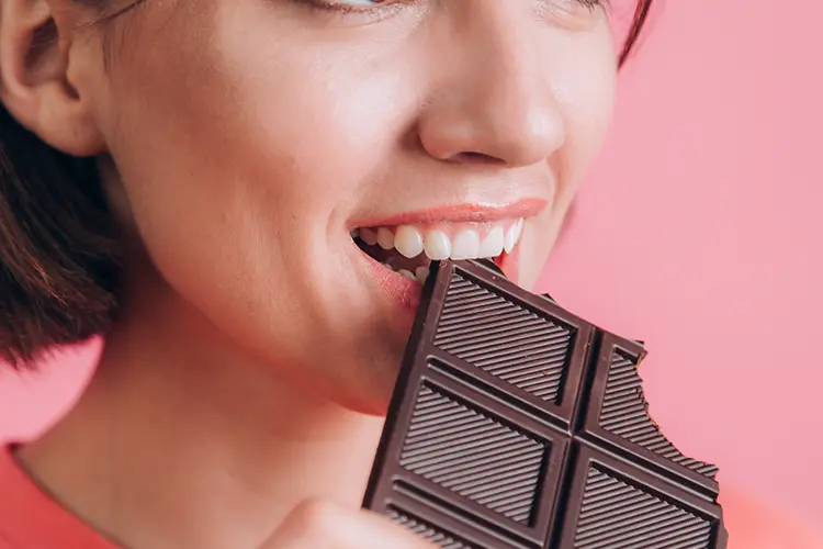 Woman eating dark chocolate — cacao flavanols have genuine research support for improving cerebral blood flow
